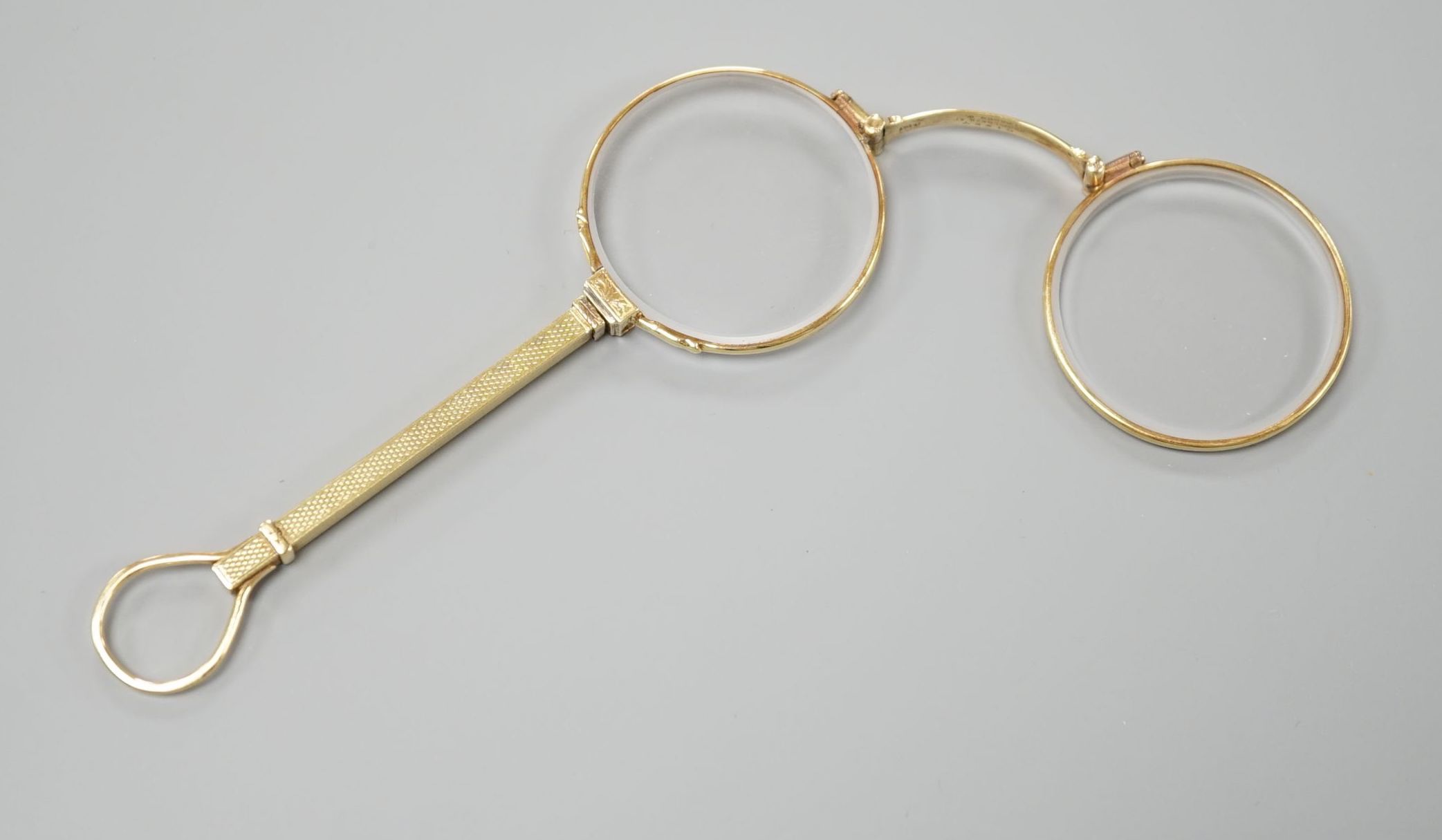 A pair of Edwardian 15ct lorgnettes, by Dixie, 20 Welbeck Street, London, with engine turned handle, 11.4cm, gross weight 28.9 grams.